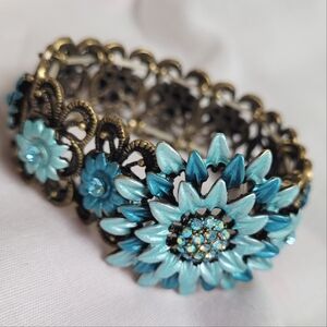 Brass floral cuff bracelet with blue floral iridescent design